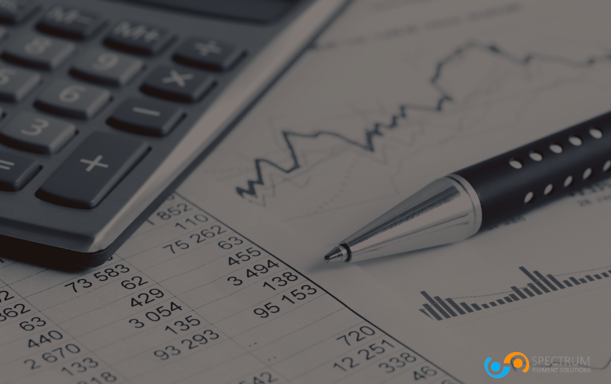 A financial report with a pen and calculator, representing data analysis and financial risk management for high-risk merchant accounts with Spectrum Payment Solutions.